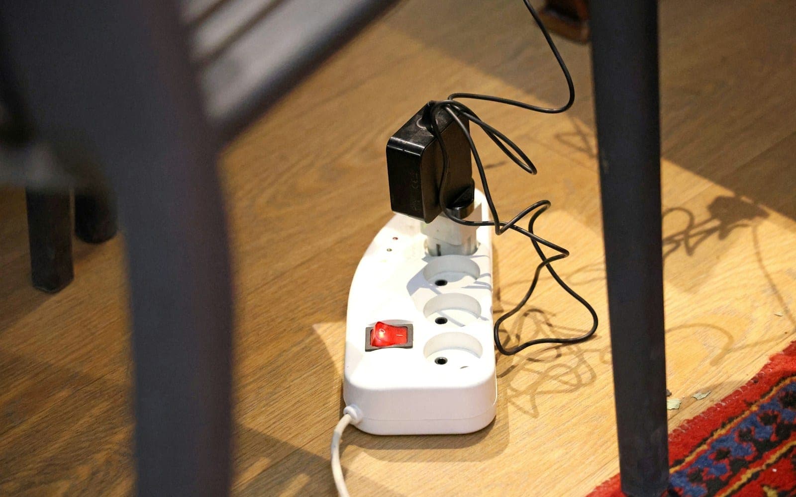 White power strip with plugs on a wooden floor