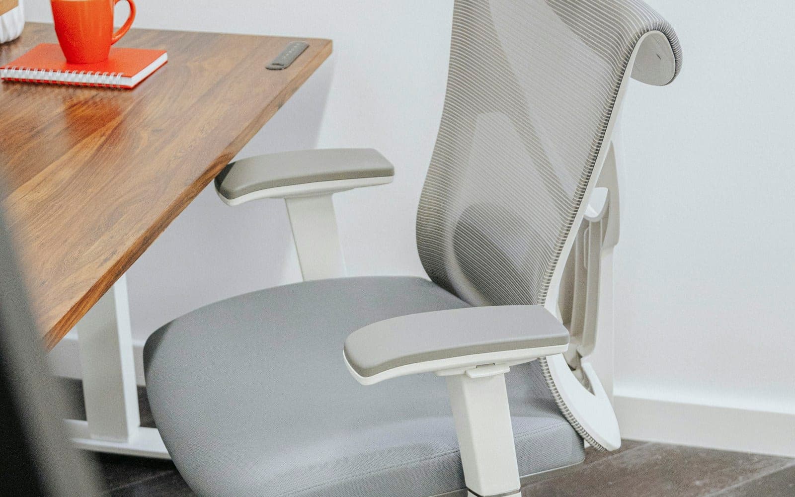 a gray office chair sitting next to a wooden table