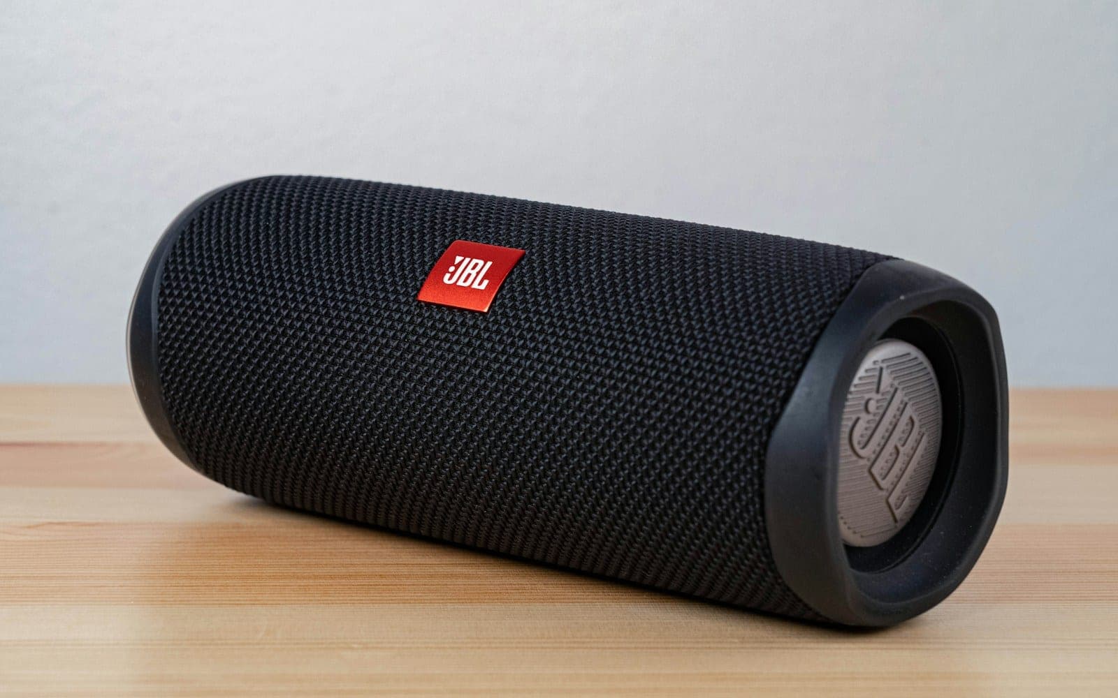 black jbl portable speaker on brown wooden table