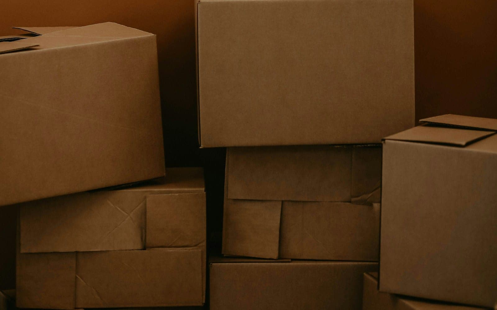 A stack of brown cardboard boxes against a solid brown background