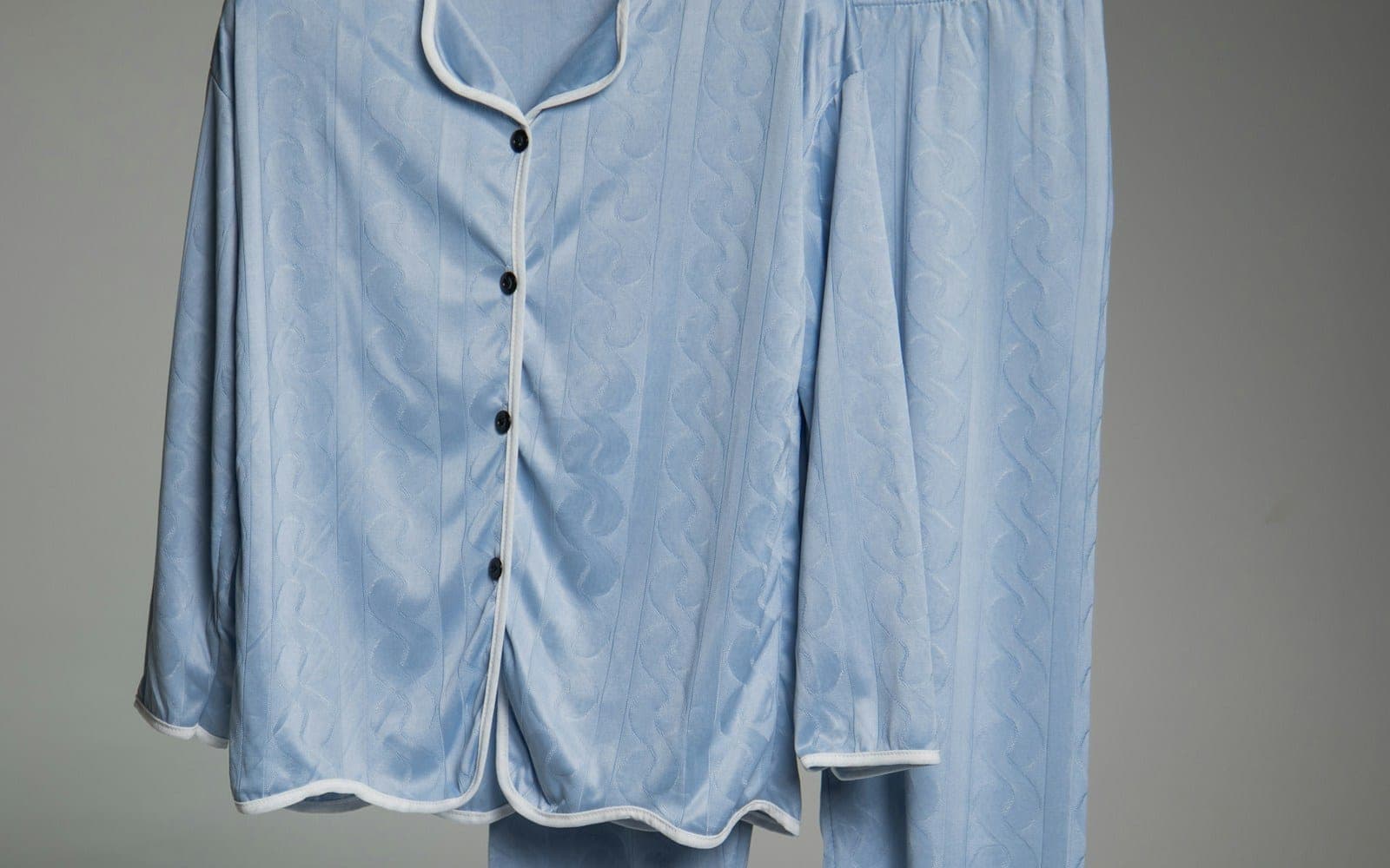 Light blue matching pyjama shirt and trousers with white trim.