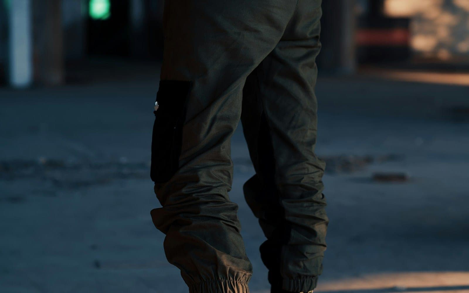 Dark jogger trousers with elasticated cuffs and side pockets.
