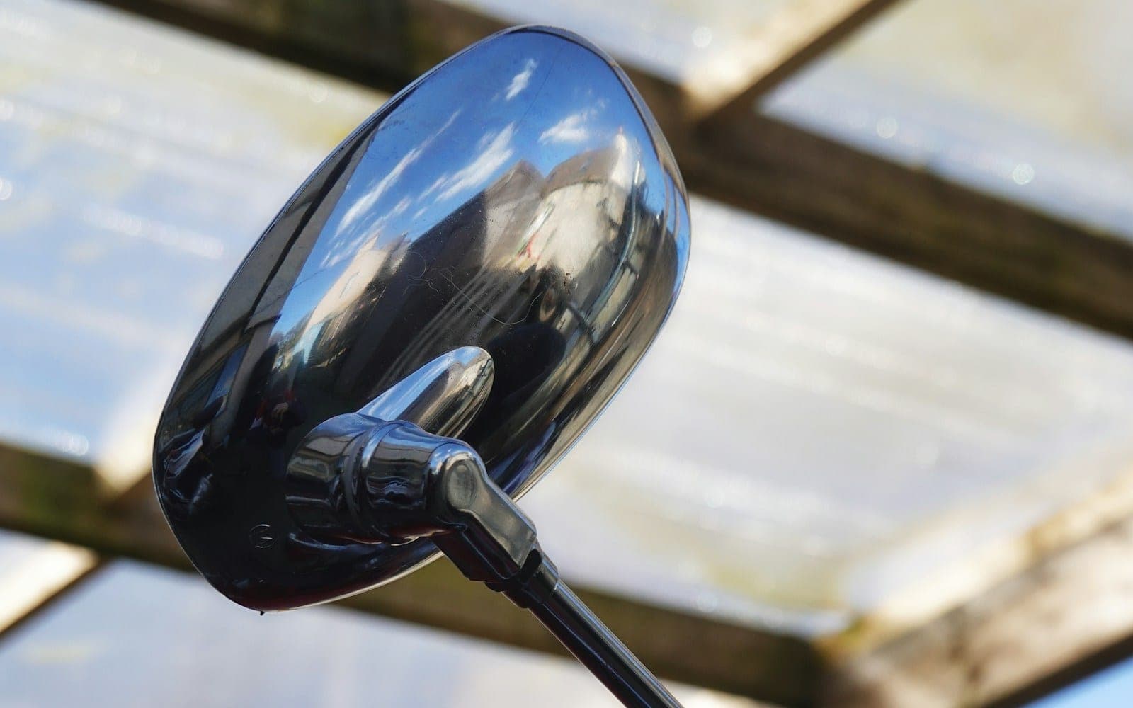 Close-up of a motorcycle handlebar and chrome mirror